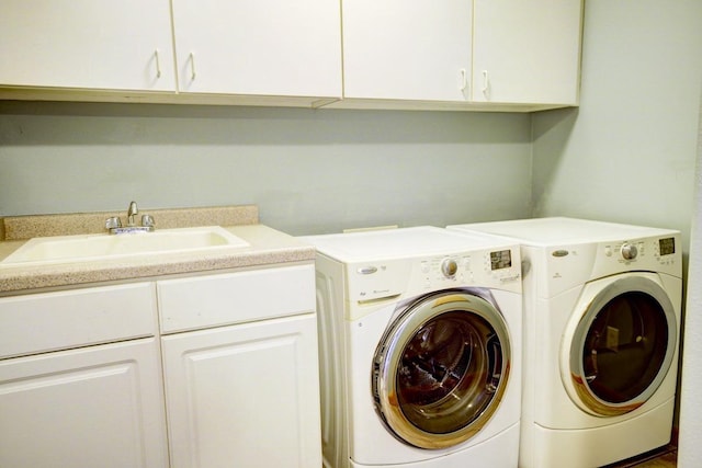 laundry area featuring sink, washing machine and dryer, and cabinets