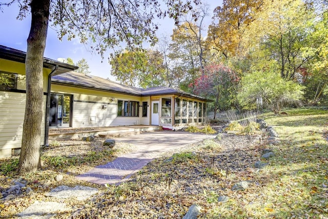 rear view of property with a sunroom