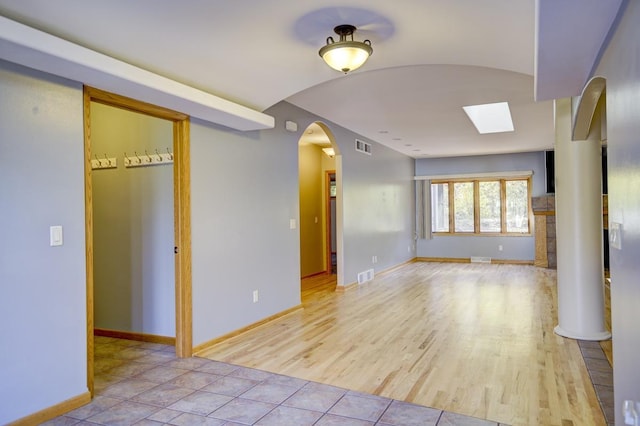 empty room with light hardwood / wood-style flooring and a skylight