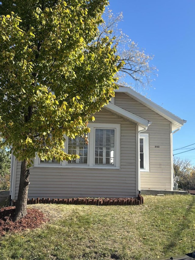 view of side of property with a lawn