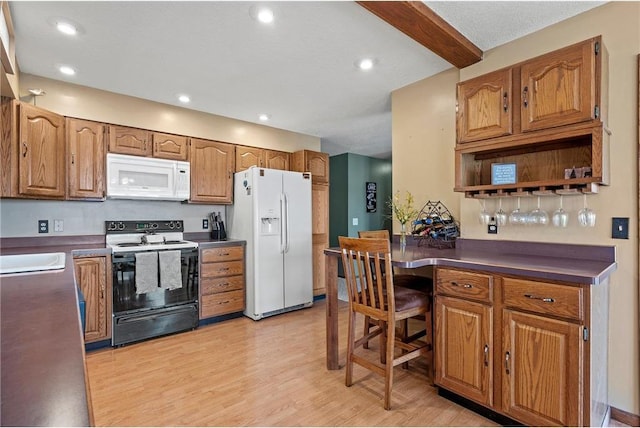 kitchen with light hardwood / wood-style flooring, beamed ceiling, and white appliances