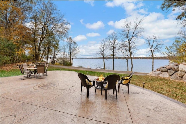 view of patio / terrace featuring a water view and a fire pit