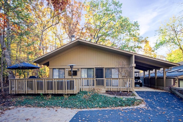 back of house with a carport and a deck