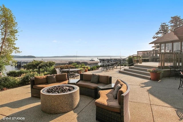 view of patio / terrace with a deck with water view and a fire pit