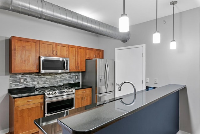 kitchen featuring appliances with stainless steel finishes, sink, backsplash, kitchen peninsula, and pendant lighting