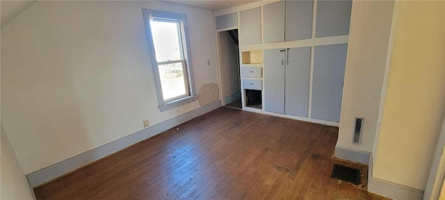 unfurnished bedroom featuring dark wood finished floors, visible vents, and baseboards