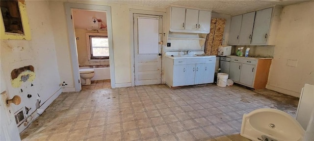 kitchen featuring light floors, light countertops, and a sink