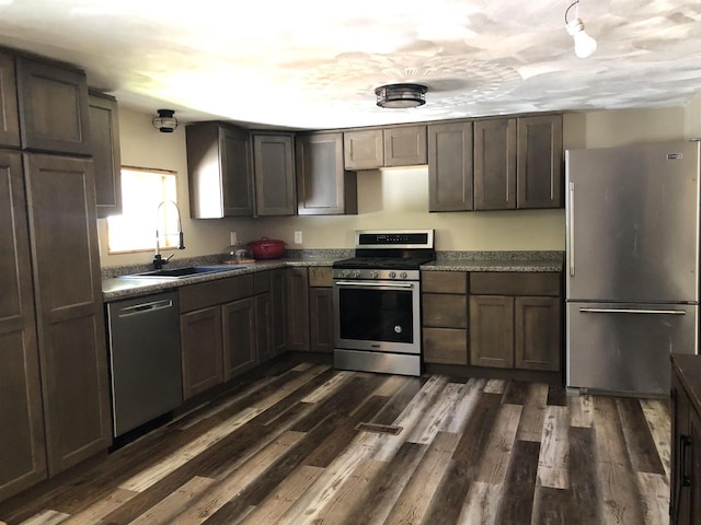 kitchen featuring dark wood-type flooring, dark brown cabinetry, stainless steel appliances, and sink