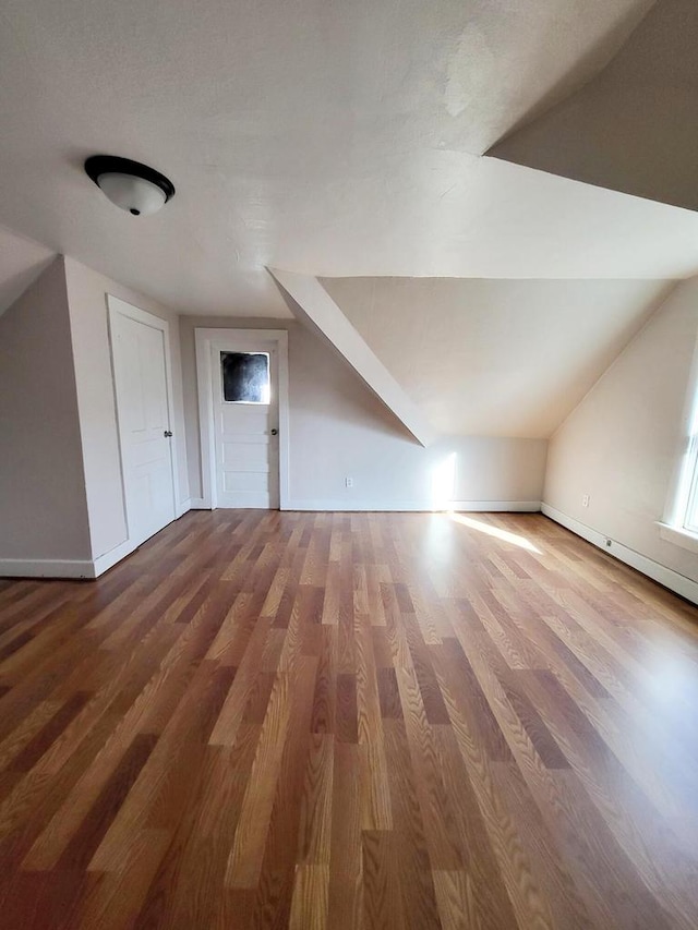 additional living space featuring hardwood / wood-style flooring and lofted ceiling