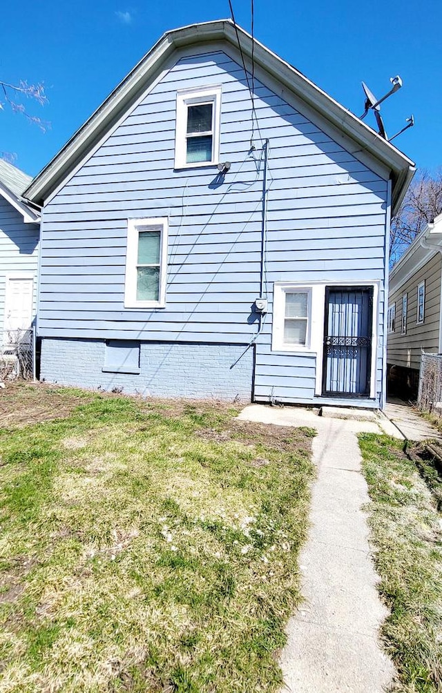 back of house featuring a lawn