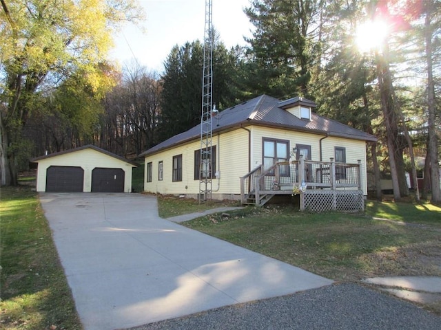 view of front of house featuring a garage, a front lawn, and an outdoor structure