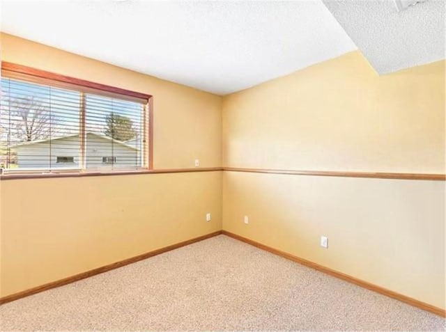 carpeted empty room with a textured ceiling