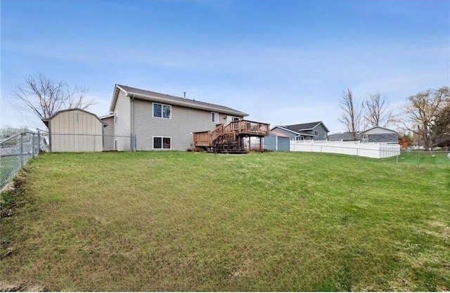 view of yard with a wooden deck and a storage shed