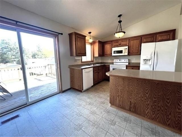 kitchen featuring lofted ceiling, sink, decorative light fixtures, and white appliances