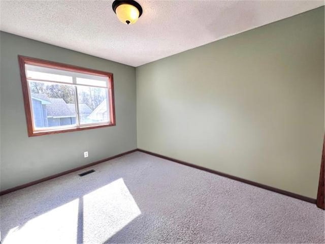 carpeted spare room featuring a textured ceiling