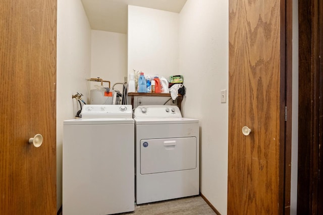 washroom with washer and clothes dryer and light hardwood / wood-style flooring