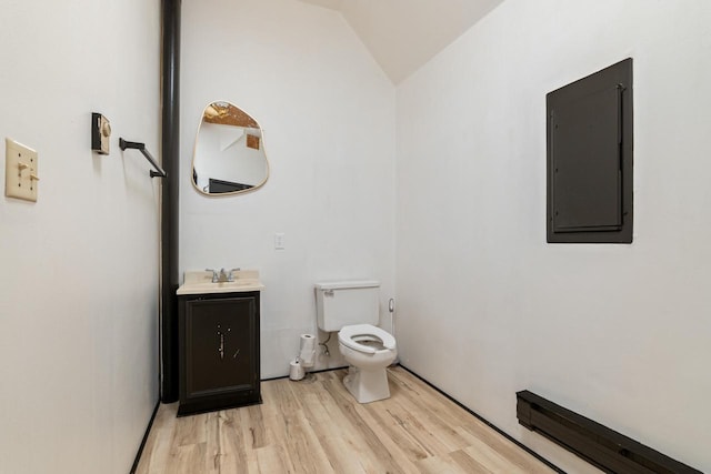 bathroom with lofted ceiling, electric panel, wood-type flooring, toilet, and vanity