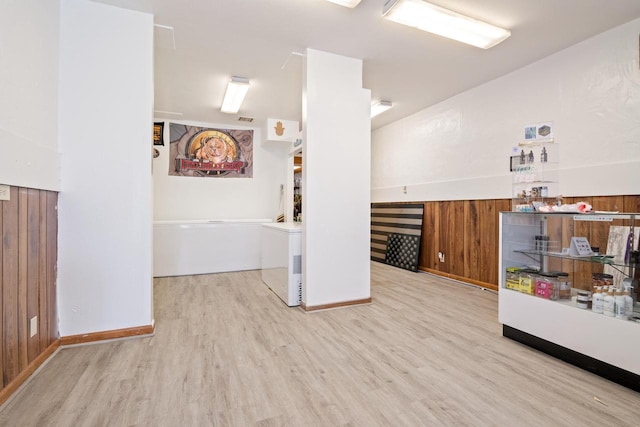 spare room featuring light wood-type flooring and wood walls