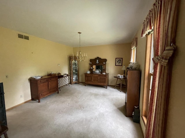 miscellaneous room featuring an inviting chandelier and light colored carpet