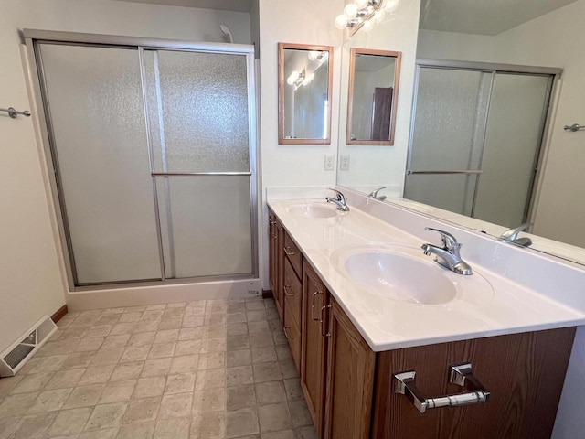 bathroom featuring vanity and a shower with shower door