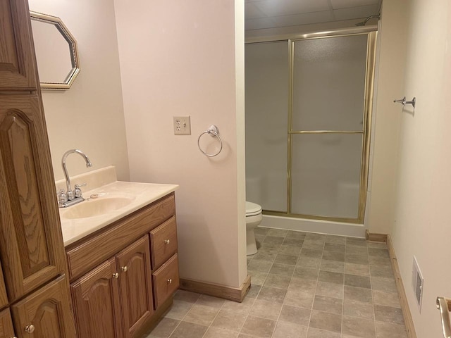 bathroom featuring vanity, a shower with shower door, toilet, and tile patterned flooring