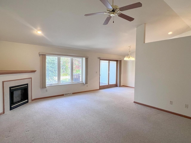 unfurnished living room featuring light colored carpet, ceiling fan with notable chandelier, and vaulted ceiling