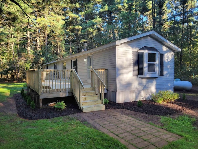 manufactured / mobile home with a deck and a front lawn