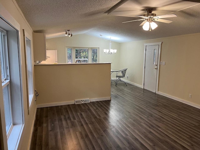 spare room featuring lofted ceiling, a textured ceiling, ceiling fan with notable chandelier, and dark hardwood / wood-style flooring