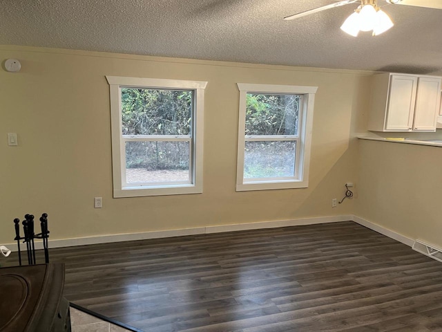 unfurnished room featuring dark hardwood / wood-style floors, a textured ceiling, and a healthy amount of sunlight