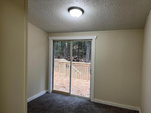 doorway featuring a textured ceiling, ornamental molding, and dark colored carpet