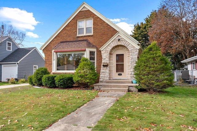 english style home with a front lawn and a garage