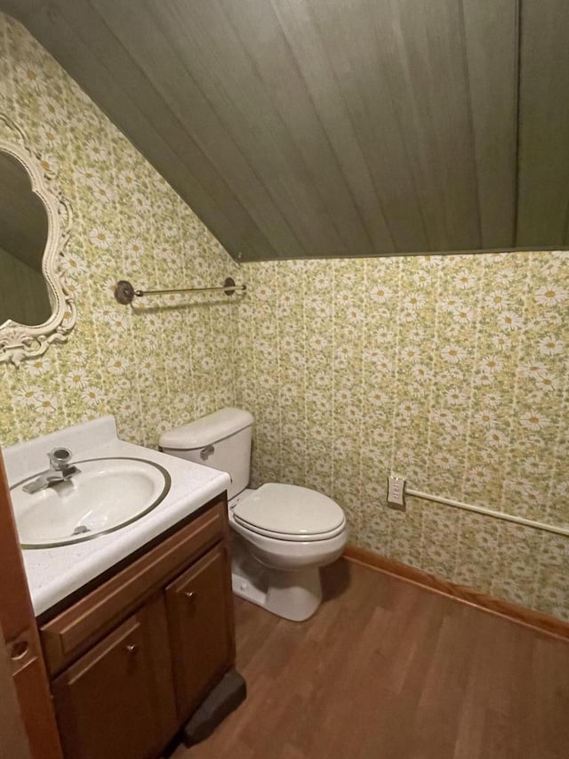 bathroom with vanity, lofted ceiling, hardwood / wood-style floors, and toilet