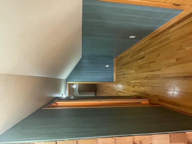 interior space featuring lofted ceiling and wooden walls