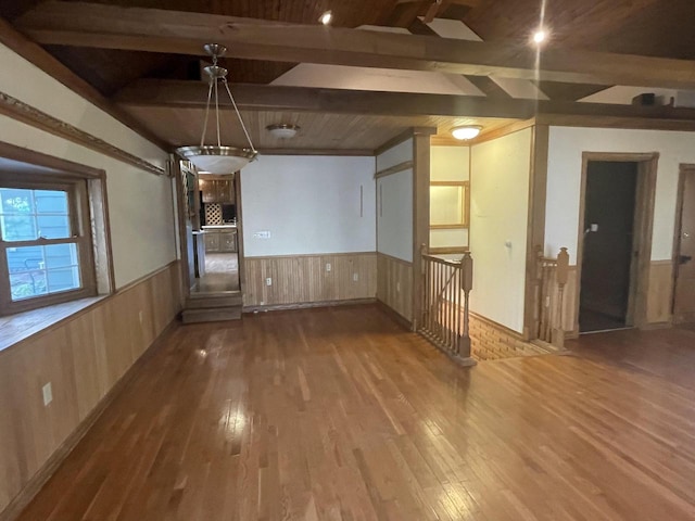 unfurnished room with beam ceiling and hardwood / wood-style flooring