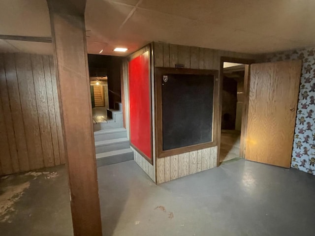 interior space featuring wood walls and concrete flooring