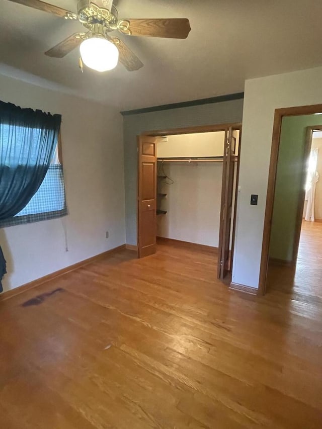 unfurnished bedroom featuring light hardwood / wood-style flooring, a closet, and ceiling fan