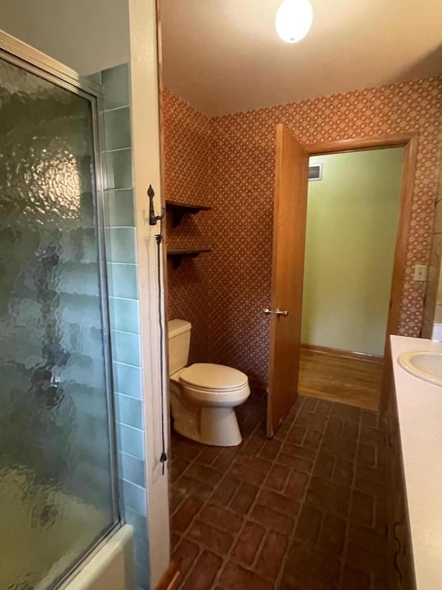 full bathroom with toilet, enclosed tub / shower combo, and vanity