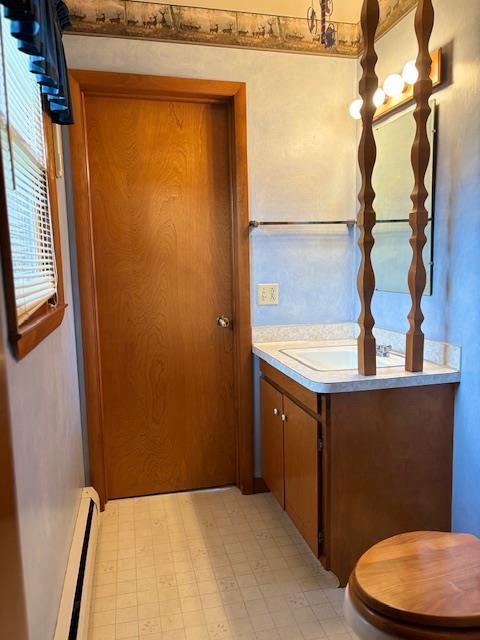 interior space featuring baseboard heating, vanity, and toilet