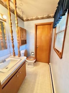 bathroom with baseboard heating, vanity, and toilet