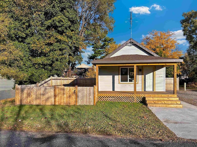 bungalow-style home featuring covered porch and a front yard