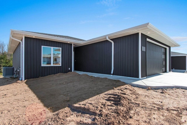 view of front facade with a detached garage and central AC