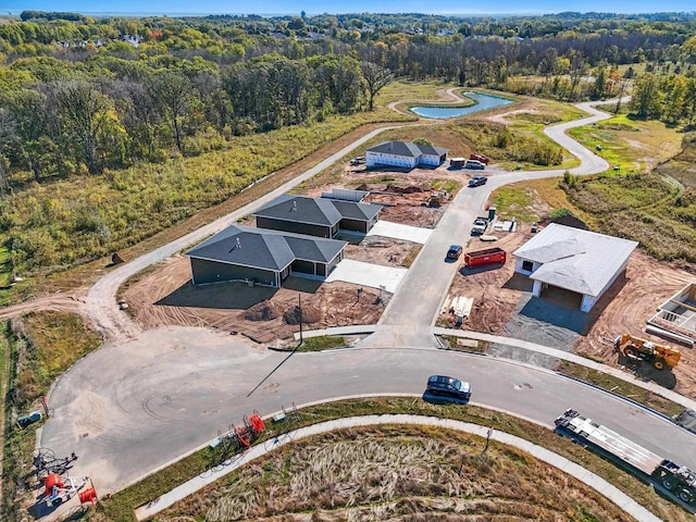 birds eye view of property featuring a water view and a view of trees