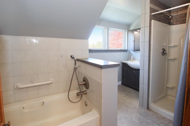 bathroom with a tub, walk in shower, vanity, and vaulted ceiling