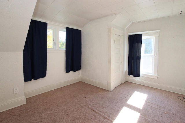 carpeted empty room with lofted ceiling and baseboards