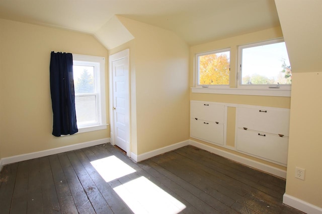 bonus room with baseboards, lofted ceiling, a healthy amount of sunlight, and dark wood-style flooring