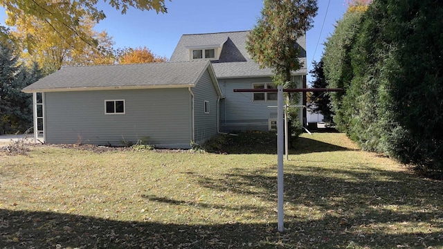 view of property exterior featuring a yard and roof with shingles