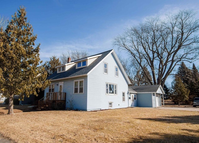 view of home's exterior with an attached garage, a lawn, roof with shingles, and a chimney