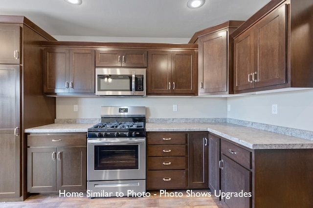 kitchen featuring appliances with stainless steel finishes, light hardwood / wood-style flooring, and dark brown cabinetry