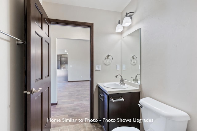 bathroom with vanity, toilet, and wood-type flooring