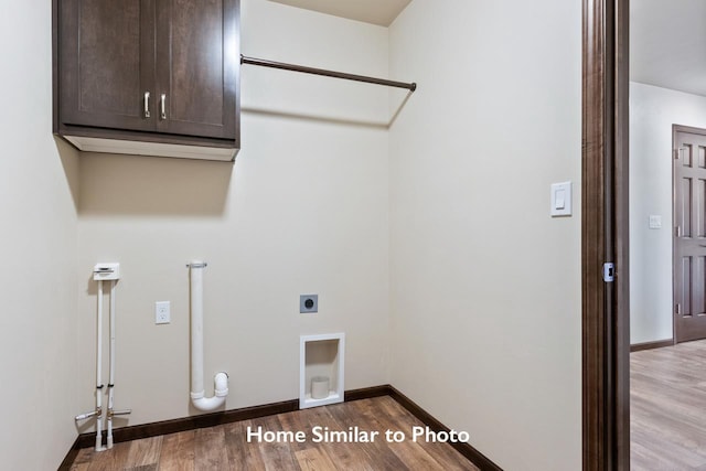 washroom featuring hardwood / wood-style floors, electric dryer hookup, and cabinets